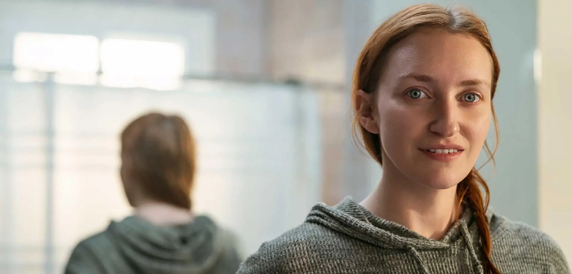 Woman smiling with her back to the mirror